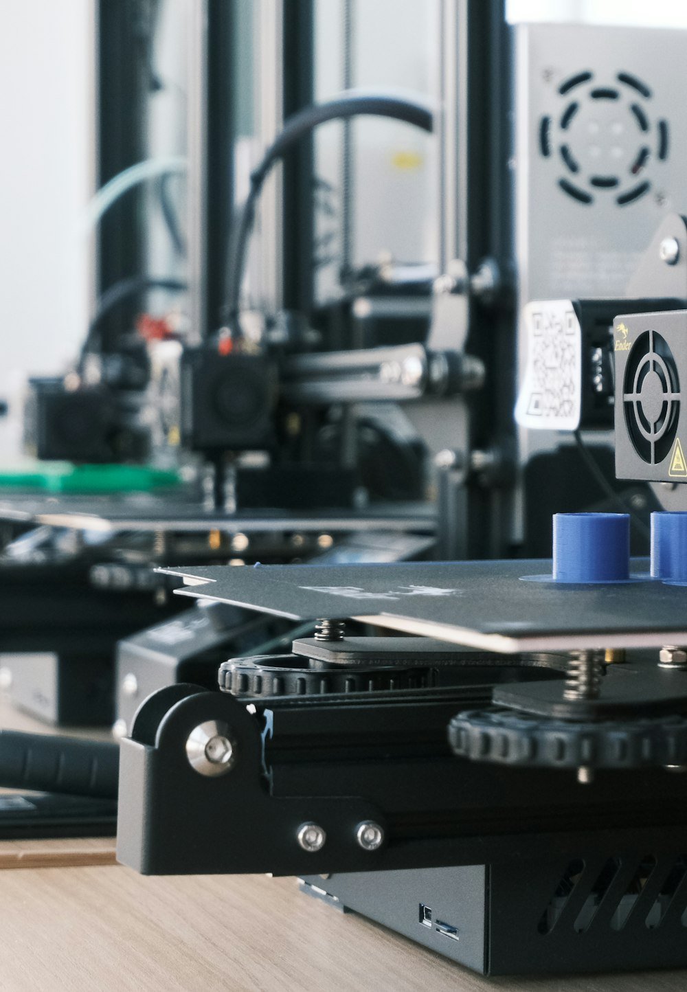 Row of 3D printers producing blue plastic parts