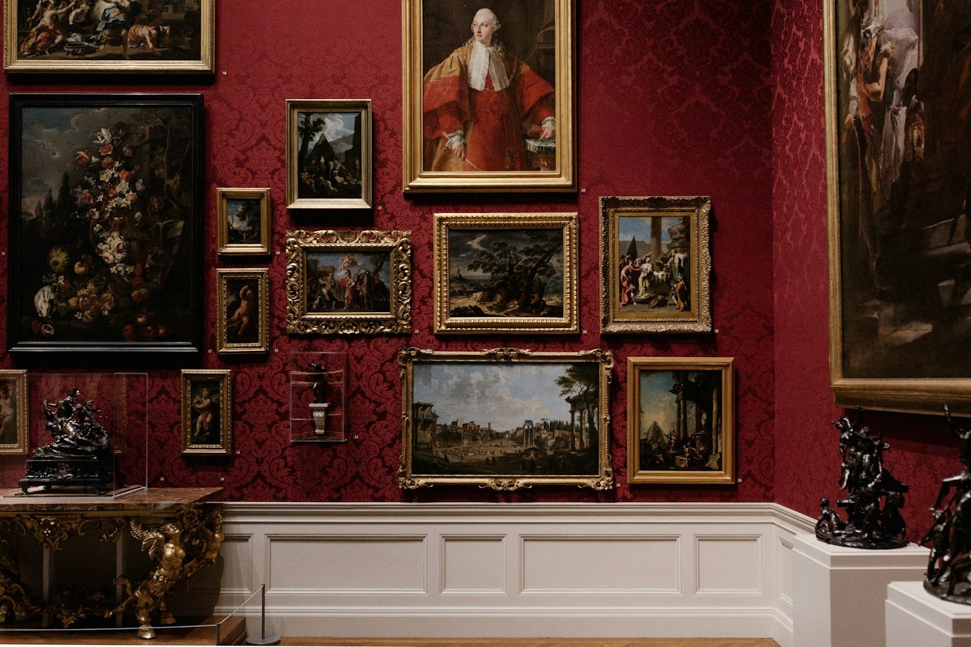 Museum gallery with framed paintings and bronze sculptures